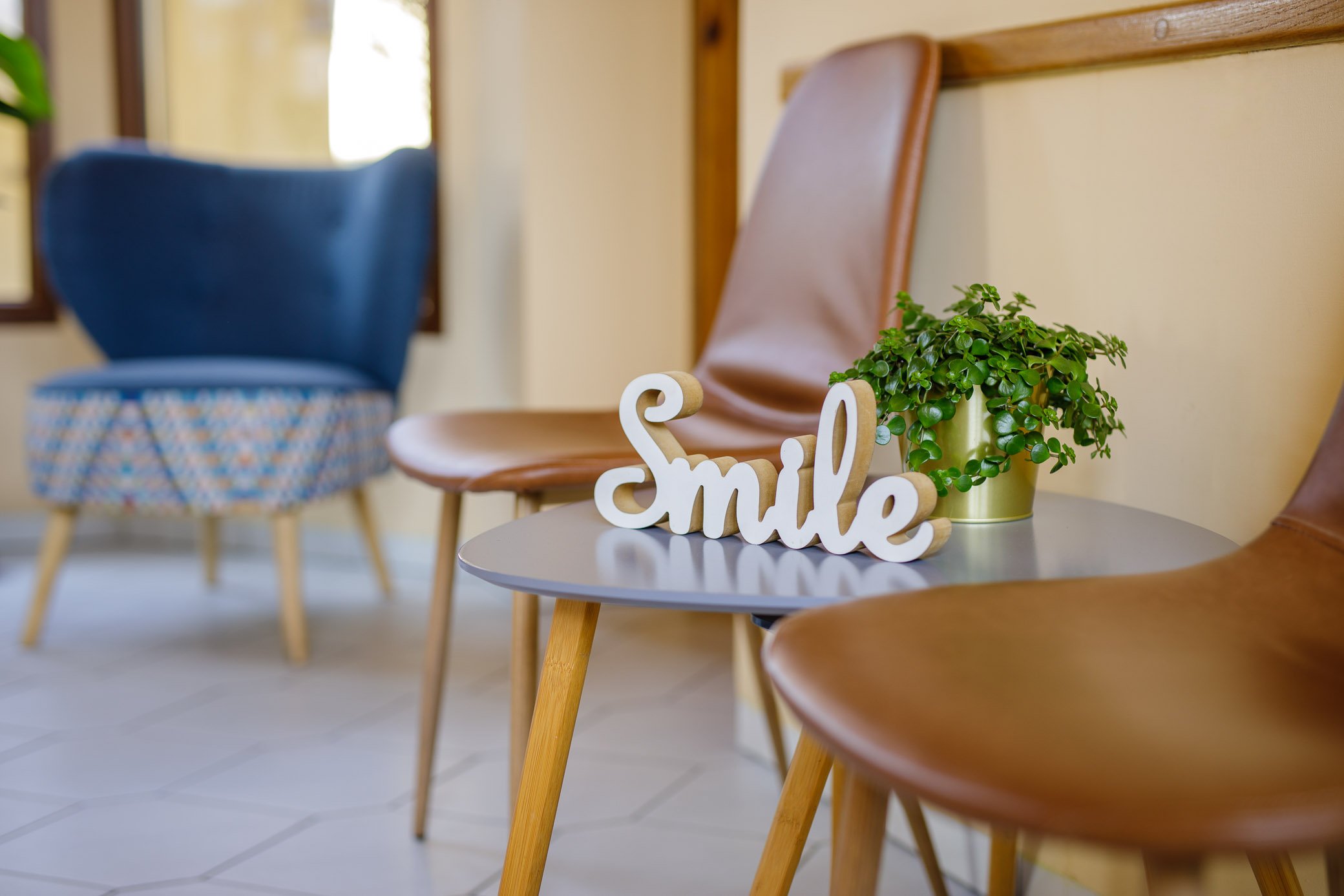 Poczekalnia gabinetu stomatologicznego krzesła roślina napis smile